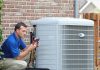 When you need to replace your HVAC system Technician servicing a home heating and cooling system