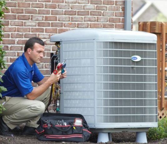 When you need to replace your HVAC system Technician servicing a home heating and cooling system
